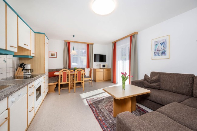 Gemütliche Wohnküche im Appartement im Haus Grafenbergblick in Wagrain mit Sitzecke, Küche und Sofa
